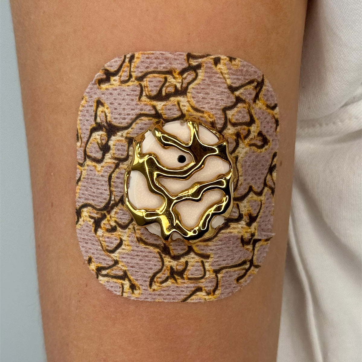 Beige Venom CGM patch with a gold finish for Dexcom G7