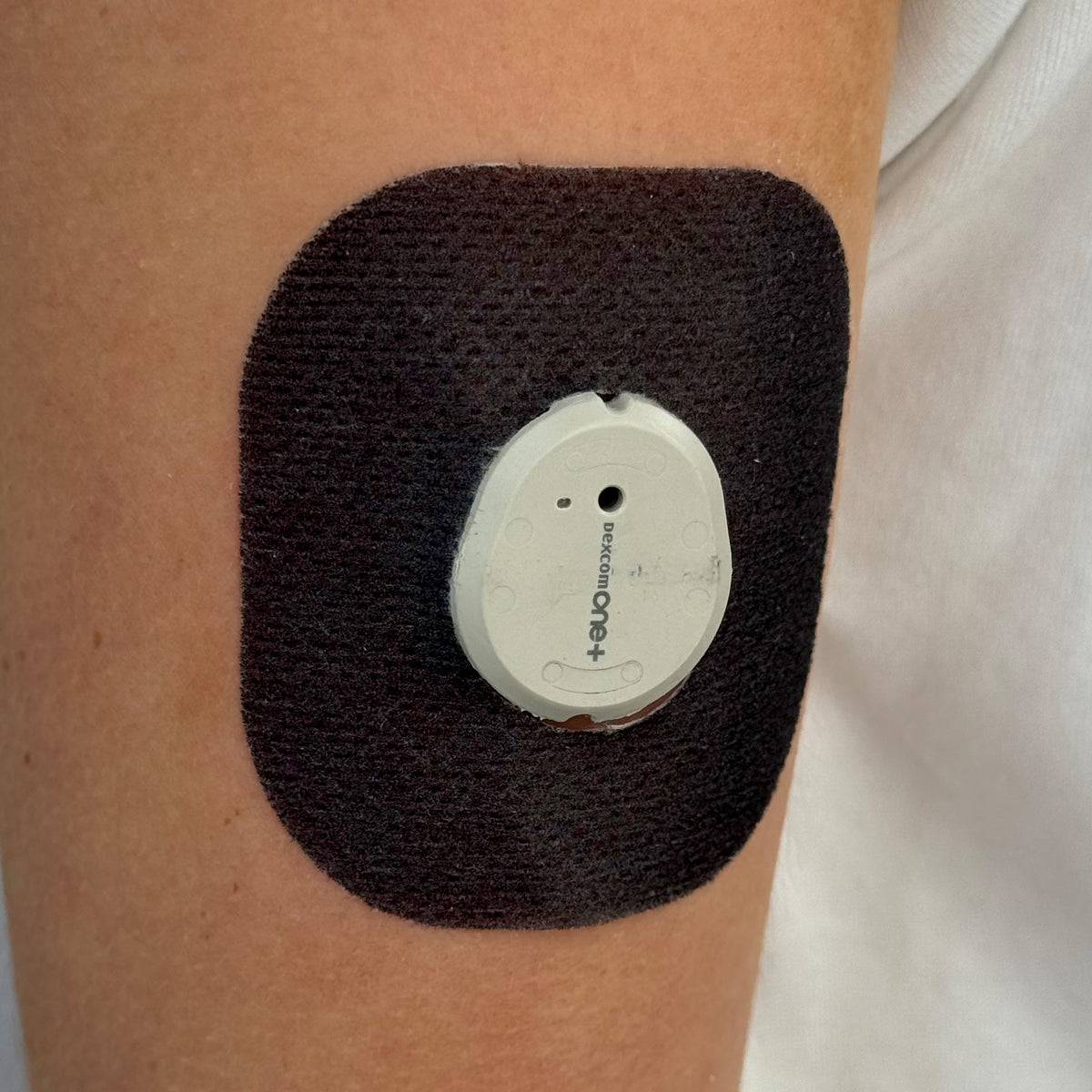 Black Everyday CGM patch for Dexcom G7, worn on the body