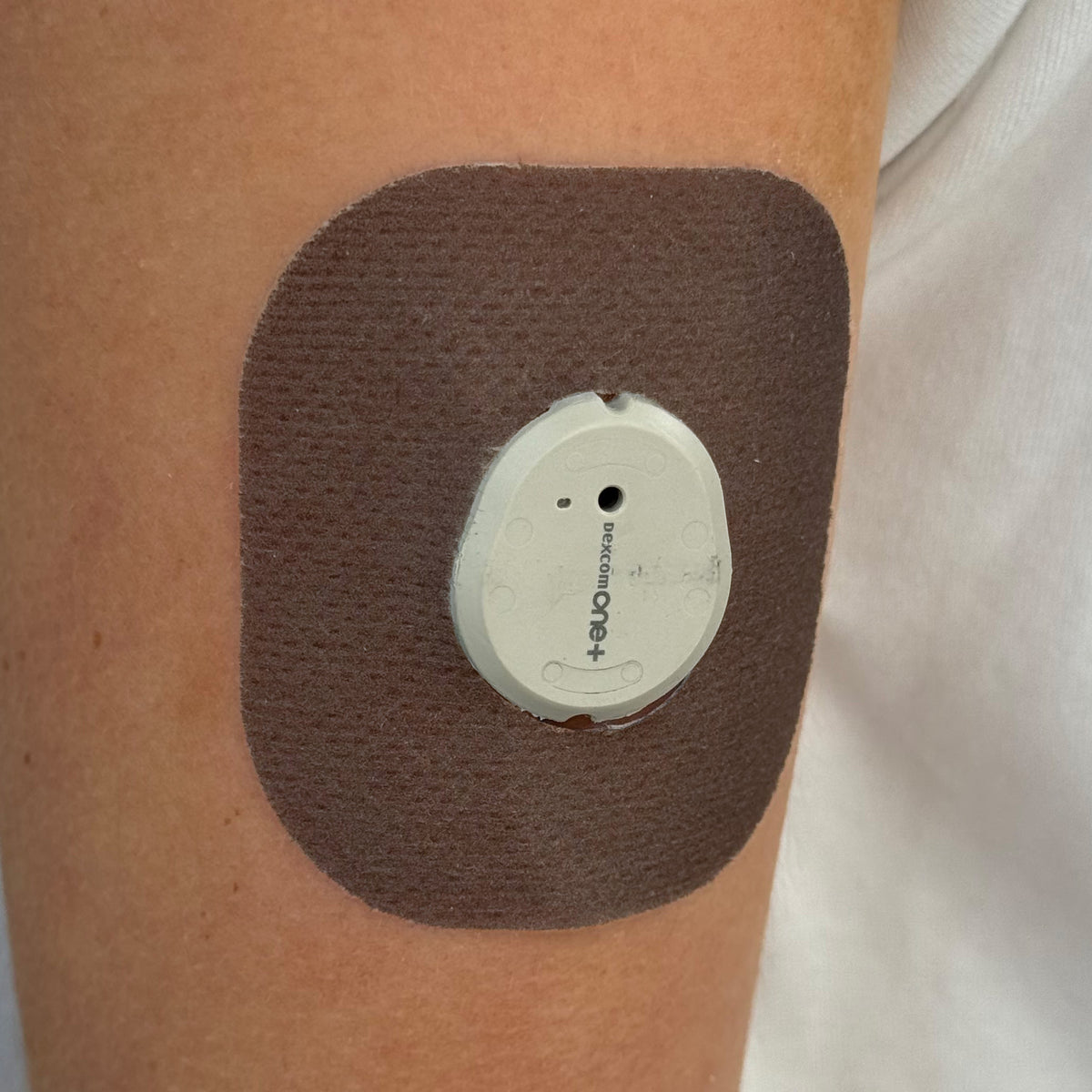 Brown Everyday CGM patch for Dexcom G7, worn on the body