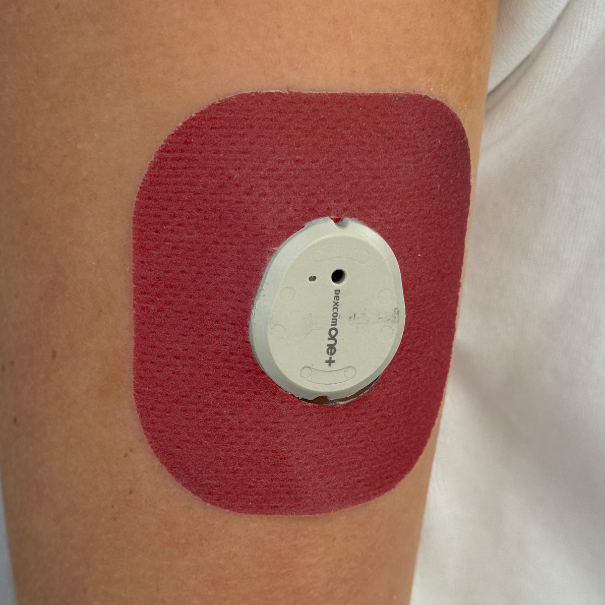 Red Everyday CGM patch for Dexcom G7, worn on the body