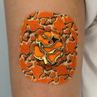 Orange Venom CGM patch with a gold finish for Dexcom G7