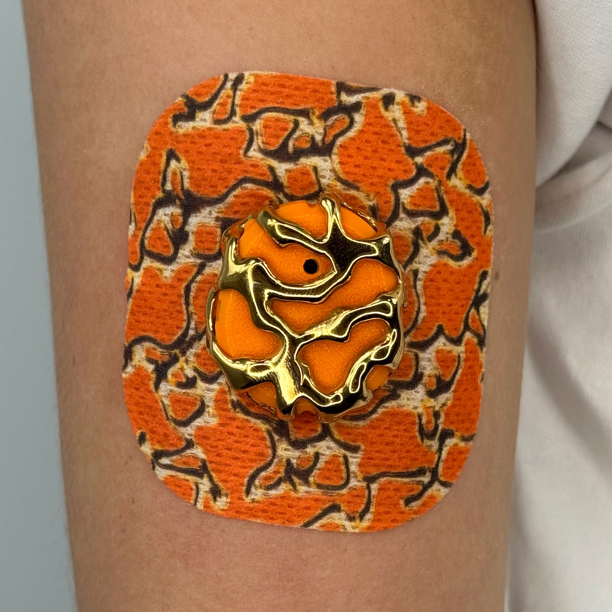 Orange Venom CGM patch with a gold finish for Dexcom G7